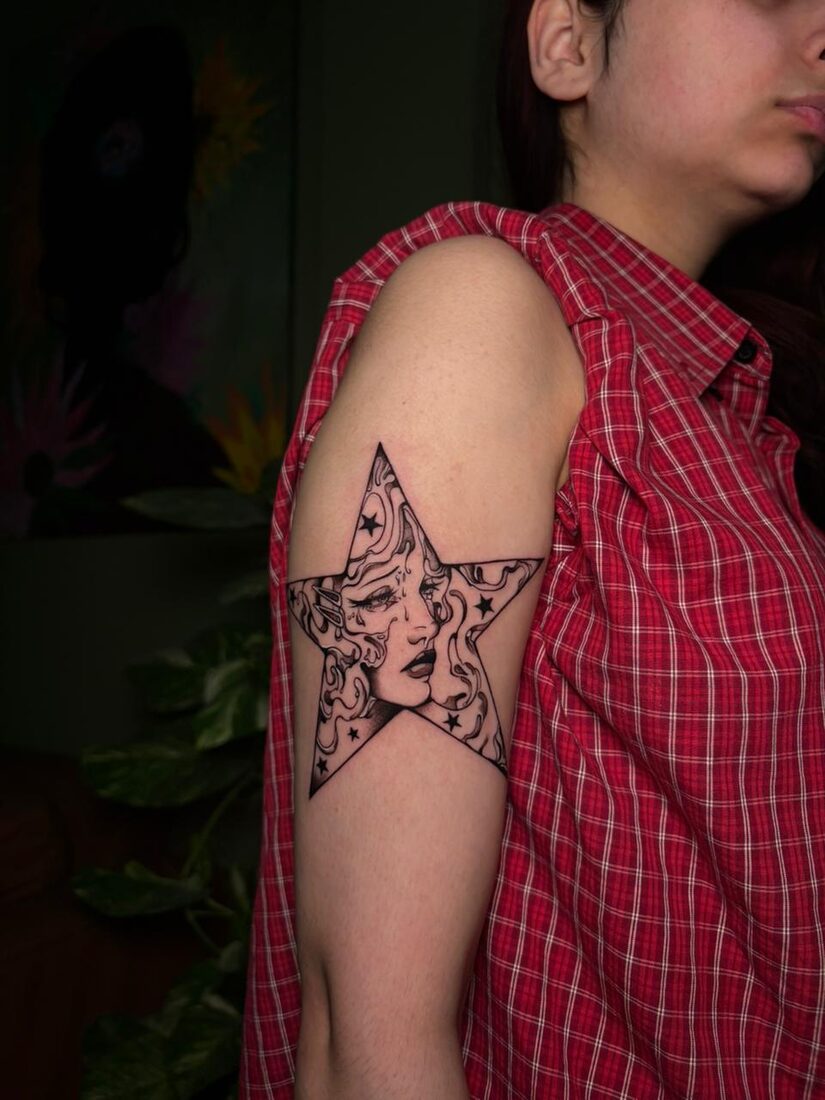 Illustrative blackwork star portrait upper arm tattoo by The Quinted
